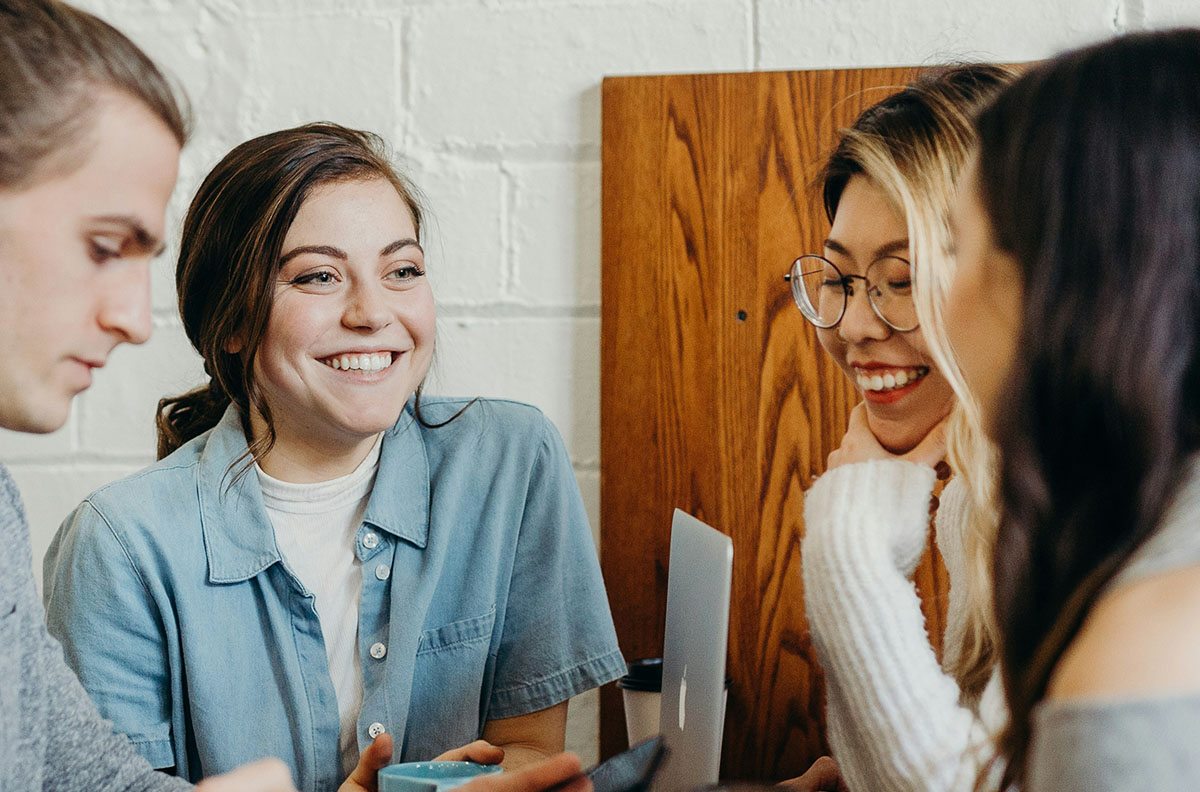 A young smiling female sitting with a group of interns.