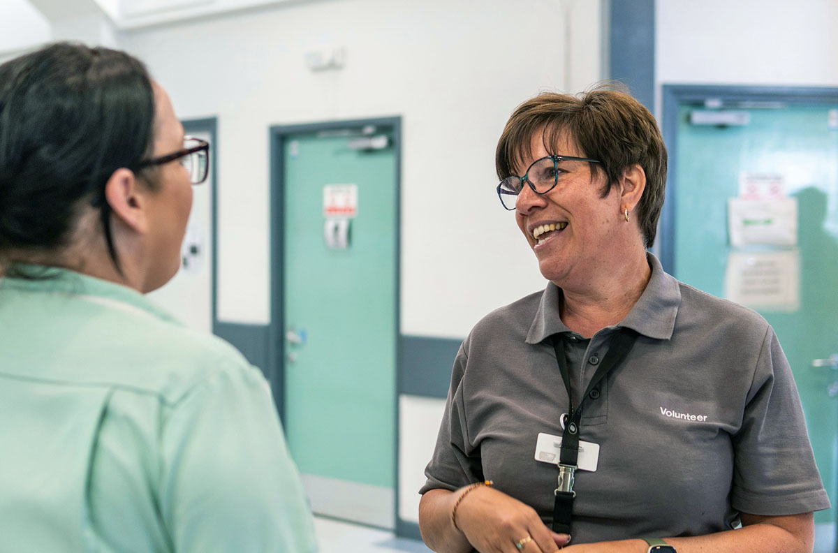 A middle-aged female volunteer talking to a woman.