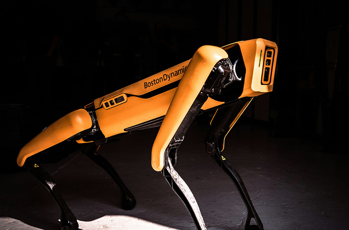 A yellow Boston Dynamic robot with four legs on display.